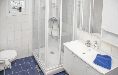 a bathroom with a shower and a sink and a toilet at 4 Bedroom Beautiful Home In Hundeidvik in Hundeidvik