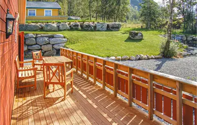 a wooden deck with a table and chairs on it at 4 Bedroom Beautiful Home In Hundeidvik in Hundeidvik