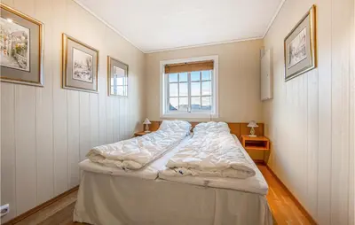 a large bed in a room with a window at Gorgeous Home In Hundeidvik in Hundeidvik