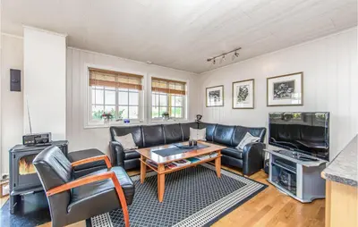 a living room with leather furniture and a tv at Gorgeous Home In Hundeidvik in Hundeidvik