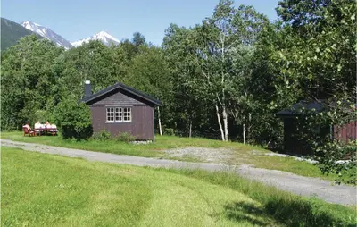 two people sitting on a bench in front of a shed at Holiday Home Isfjorden Isfjorden in Isfjorden
