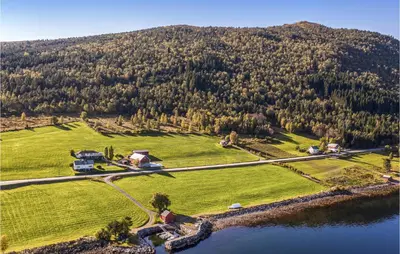 an aerial view of a house on a hill next to a lake at Holiday Home Vågstranda Hjelvik Ii in Hjelvik