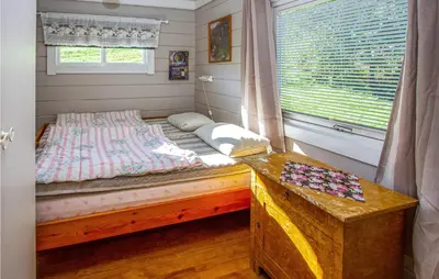 a small bedroom with a bed and a window at Holiday Home Vågstranda Hjelvik Ii in Hjelvik