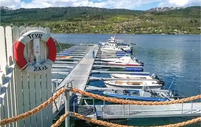 a group of boats docked at a dock in the water at Solhavn in Eidsvåg