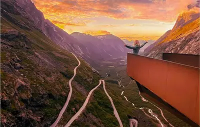 a person standing on top of a mountain with a road at Solhavn in Eidsvåg