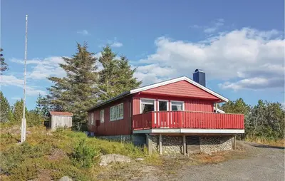 a red house with a balcony on a hill at Holiday Home Farstad Rævhaugen in Farstad