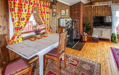 a living room with a table and a kitchen at Holiday Home Farstad Rævhaugen in Farstad