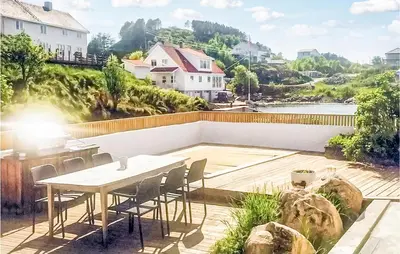 a patio with a table and chairs on top of a house at Evastua in Averoy