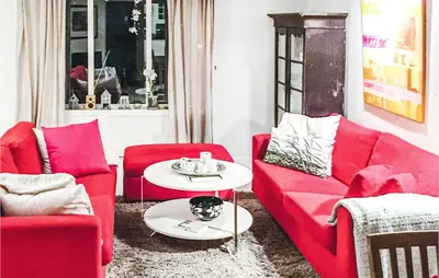a living room with red furniture and a dog on a table at Evastua in Averoy