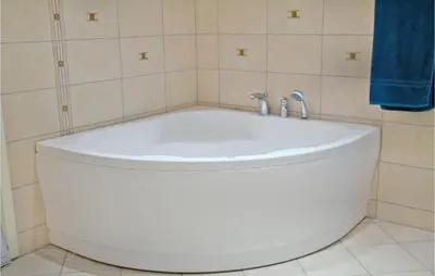 a bath tub in a bathroom with a blue shower curtain at 4 Bedroom Lovely Home In Kvisvik in Kvisvik