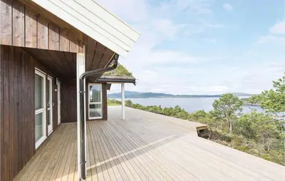 a wooden deck with a view of the water at 4 Bedroom Lovely Home In Kvisvik in Kvisvik
