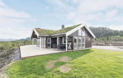 a house with a grass roof with a deck at 4 Bedroom Lovely Home In Kvisvik in Kvisvik
