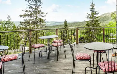 a patio with tables and chairs on a deck at Amazing Home In Trysil With Sauna in Trysil