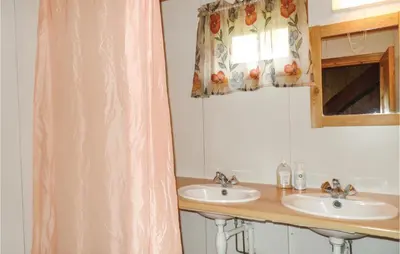 a bathroom with two sinks and a window at Storhytta in Vinstra