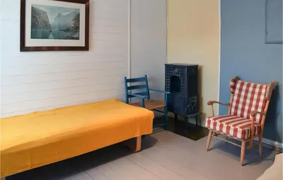 a bedroom with a bed and a chair and a stove at 3 Bedroom Amazing Home In Vestsida in Fall