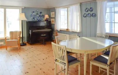 a dining room with a table and chairs and a piano at 3 Bedroom Amazing Home In Vestsida in Fall