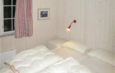 a bed with white sheets and a lamp in a room at Holiday Home Gålå Peer Gyntlia in Gålå