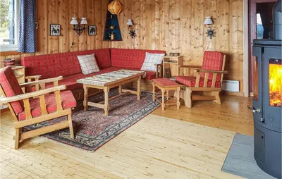a living room with a red couch and tables and chairs at Trollbu Granåsenfefor in Vinstra