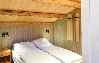 a bed in a room with a wooden ceiling at Holiday Home Sjusjøen Tyrily in Sjusjøen