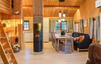 a living room with a fireplace and a dining room at Holiday Home Sjusjøen Tyrily in Sjusjøen