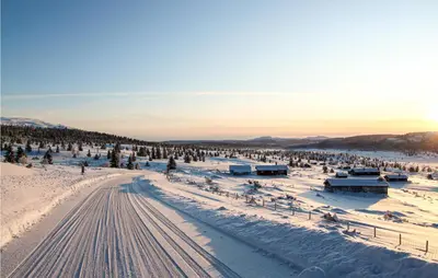 a snowy field with a road in the snow at Holiday Home Ringebu Måsåplassen Ii in Ringebu
