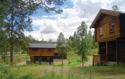 a large wooden house in the middle of a field at Holiday Home Ringebu Måsåplassen Ii in Ringebu