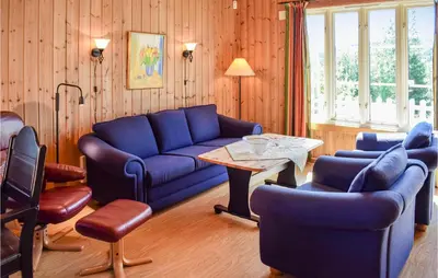 a living room with a blue couch and a table at Holiday Home Hunndal Skumlivegen