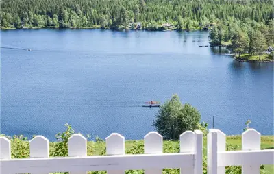 a white fence with a view of a lake at Holiday Home Hunndal Skumlivegen