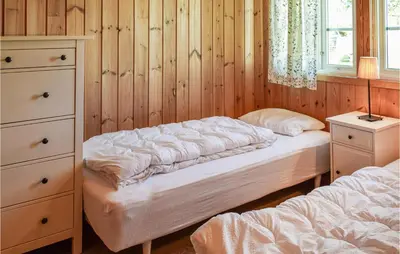 a bedroom with two beds and a dresser at Holiday Home Hunndal Skumlivegen