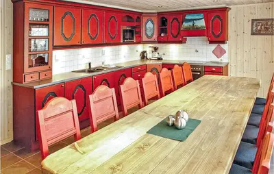 a kitchen with a wooden table and orange chairs at Skarsnuten in Hemsedal