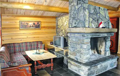 a living room with a stone fireplace and a tv at Skarsnuten in Hemsedal