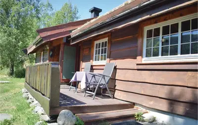 a wooden house with a table on a deck at Holde in Hemsedal