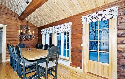 a dining room with a table and chairs and windows at Holiday Home Flå Øvre Reinsjøfjell in Flå