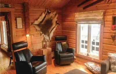 a living room with two chairs and a log wall at Holiday Home Flå Øvre Reinsjøfjell in Flå
