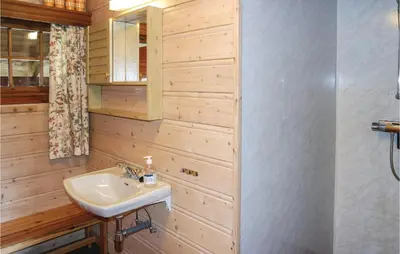a bathroom with a sink and a wooden wall at Holiday Home Hemsedal Rusto Raunhaug in Hemsedal