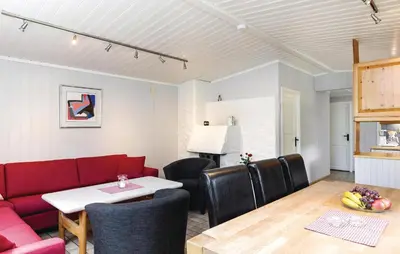 a living room with a red couch and a table at Vinjebu in Hemsedal