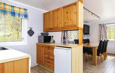 a kitchen with wooden cabinets and a table with chairs at Vinjebu in Hemsedal