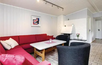 a living room with a red couch and a table at Vinjebu in Hemsedal