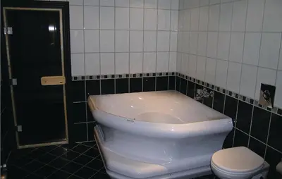 a bathroom with a white toilet and a black tiled wall at Holiday Home Hemsedal Høgeloft in Hemsedal