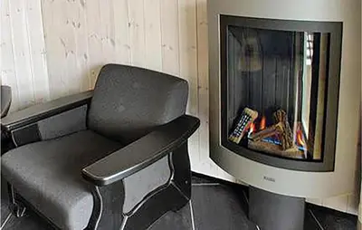 a chair in front of a fireplace with a tv at Gorgeous Apartment In Hemsedal in Hemsedal