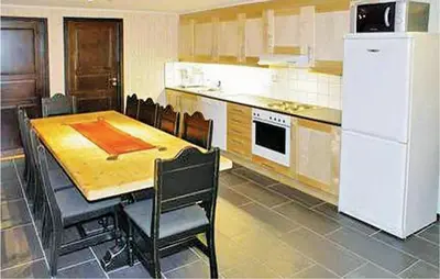 a kitchen with a table and a white refrigerator at Nice Apartment In Hemsedal With Sauna in Hemsedal