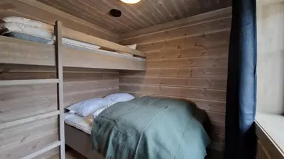 a bedroom with a bunk bed in a wooden cabin at Mlodge - The Mountain Lodge in Sogndal