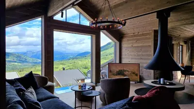 a living room with a couch and a large window at Mlodge - The Mountain Lodge in Sogndal