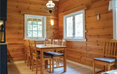 a dining room with a wooden table and chairs at Sundflathytta in Nesland