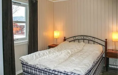 a bed in a bedroom with two lamps and a window at Lovely Home In Rauland With Sauna in Rauland