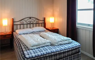 a bedroom with a bed with pillows and two lamps at Lovely Home In Rauland With Sauna in Rauland