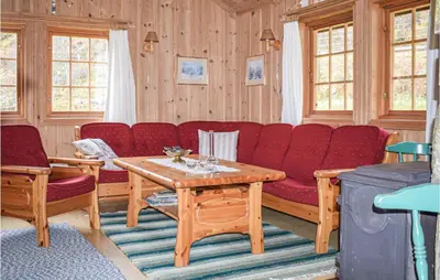 a living room with a red couch and a table at Awesome Home In Rauland With Kitchen in Rauland