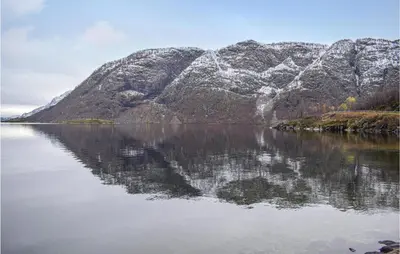 a mountain reflecting in a body of water at Awesome Home In Rauland With Kitchen in Rauland