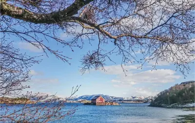 a red barn in the middle of a lake at Holiday Home Vallersund Nausthylla Haldorhamn in Valsøya