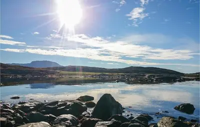 a view of a lake with the sun in the sky at Holiday Home Vallersund Nausthylla Haldorhamn in Valsøya